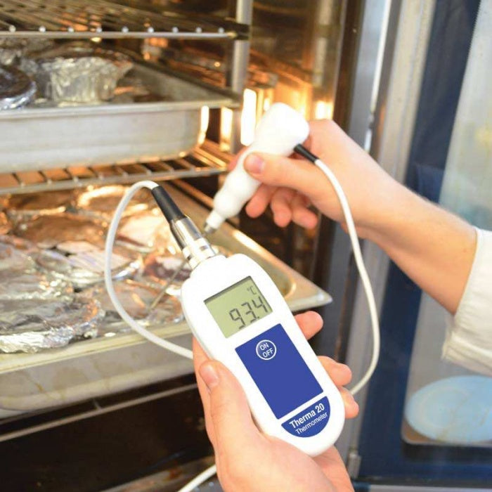 Un particulier utilise un thermomètre Therma 20 pour applications HACCP de Thermomètre.fr, accompagné d'un certificat d'étalonnage, pour mesurer la température d'un aliment enveloppé dans du papier d'aluminium à l'intérieur d'un four, qui affiche une lecture de 93,4°C sur l'écran numérique.